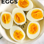 Hard Boiled Eggs cut in half in a bowl with writing
