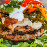 Fajita Grilled Turkey Burgers on a bed of lettuce with toppings and writing