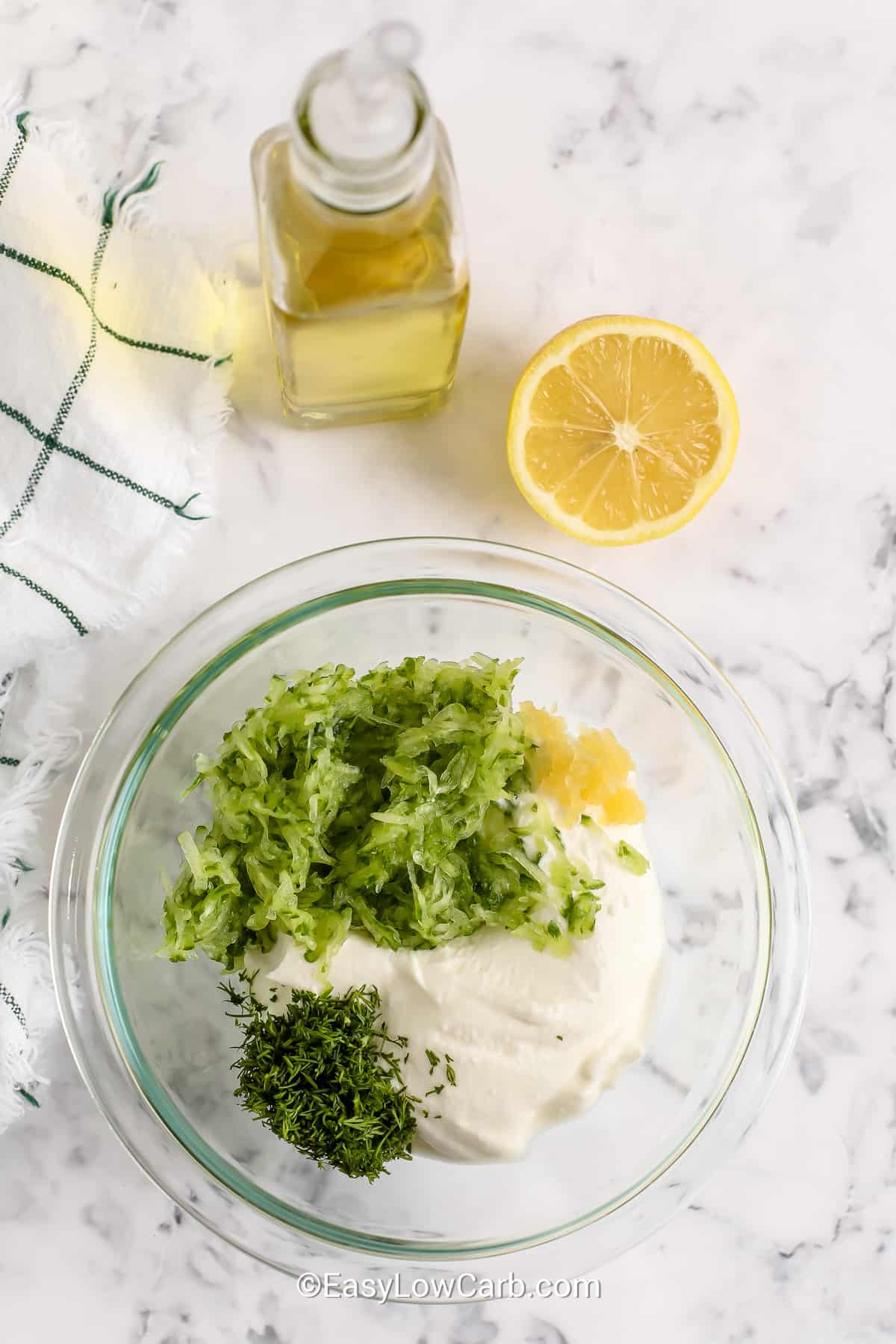 ingredients for homemade tzatziki in a clear mixing bowl