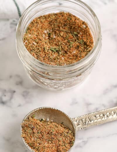 chicken seasoning in a jar and on a silver measuring spoon