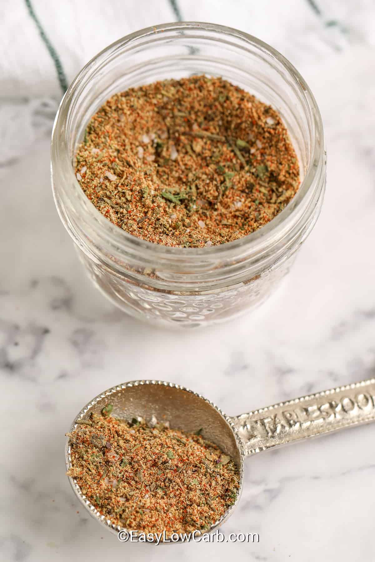 chicken seasoning in a jar and on a silver measuring spoon