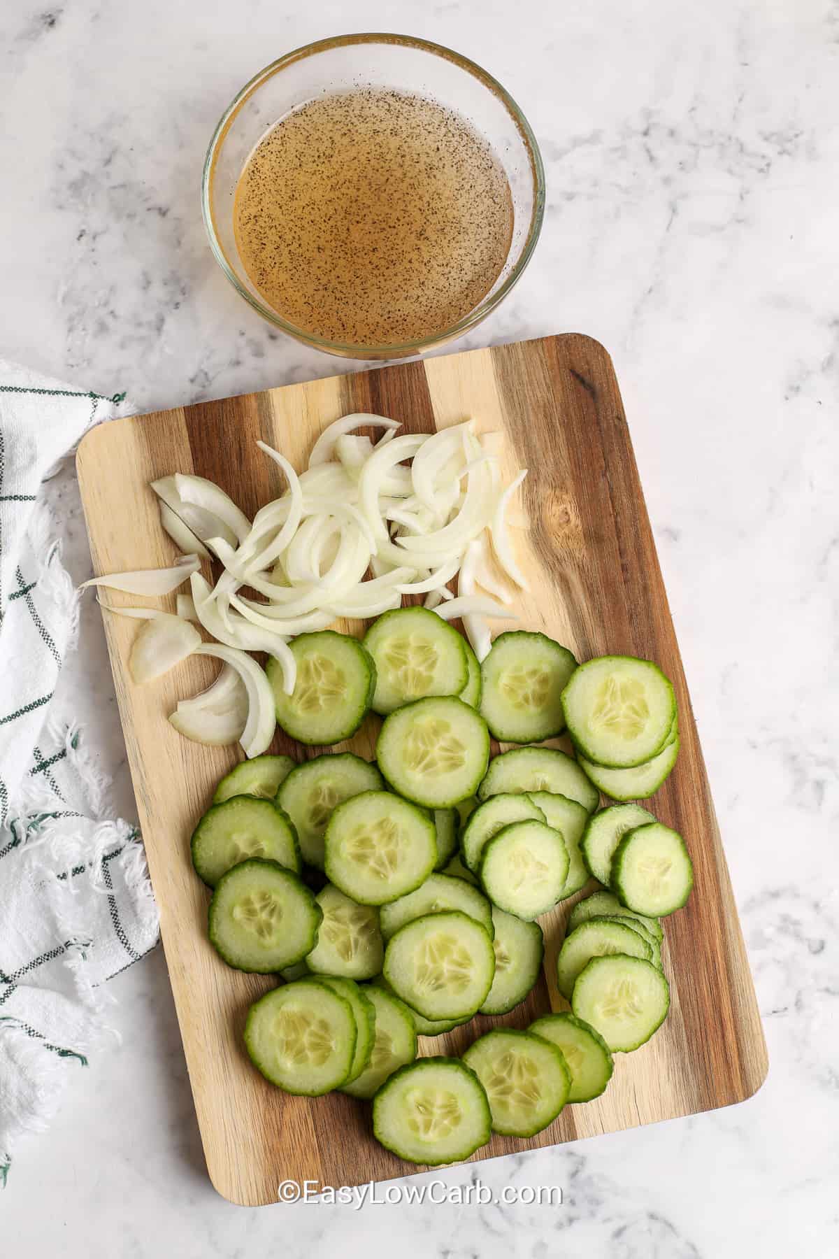 sliced cucumber and onions on a cutting board