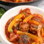 italian sausage and peppers in a white bowl