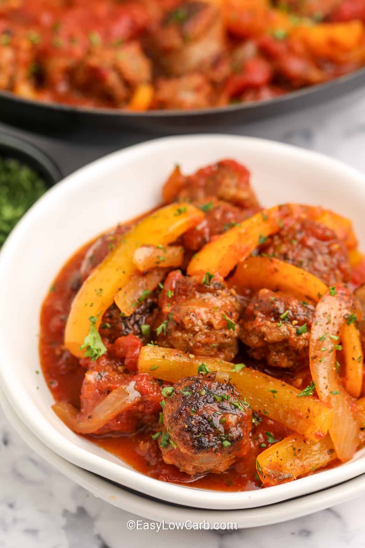 italian sausage and peppers in a white bowl