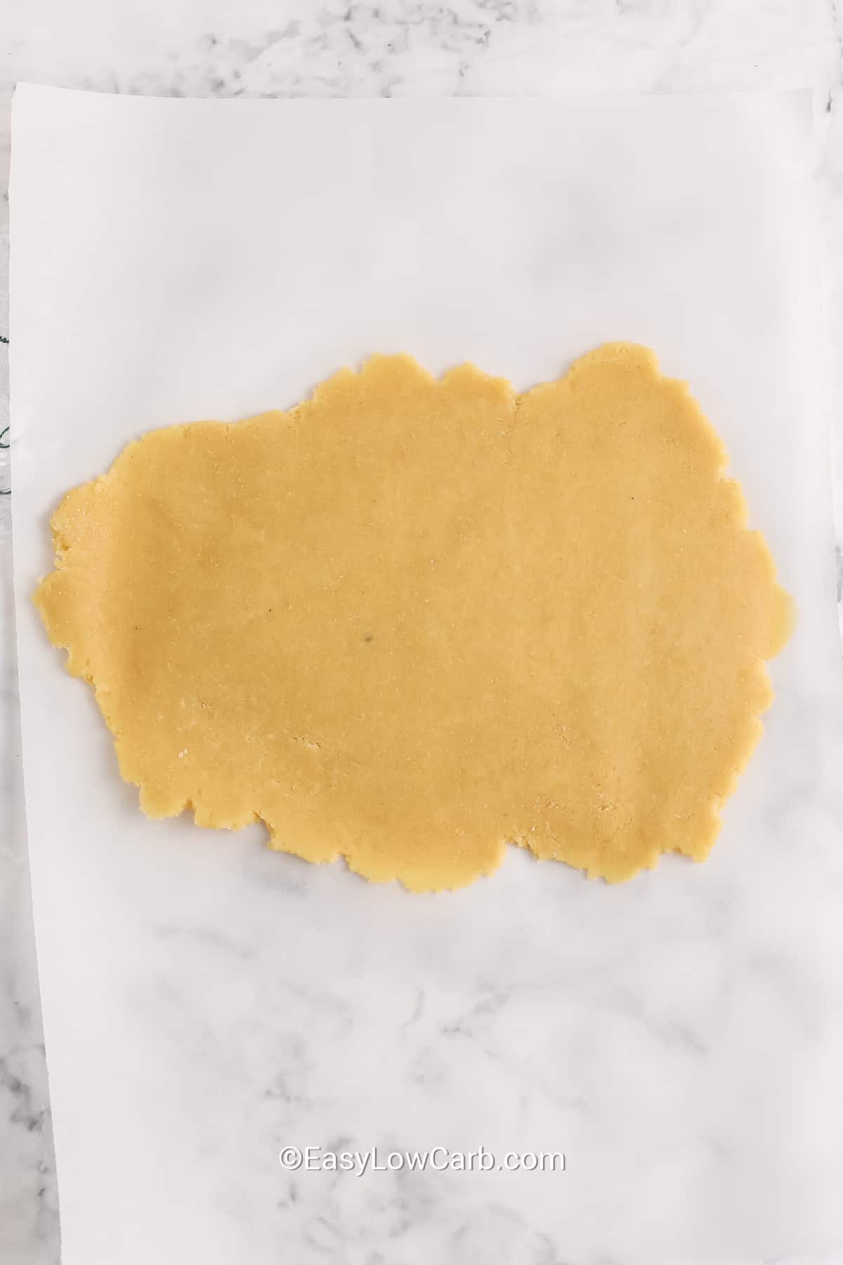 Keto crackers dough flattened on parchment paper