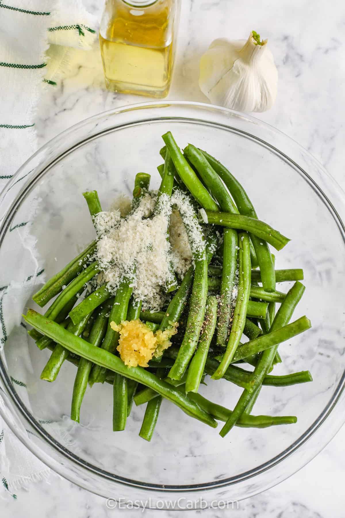 adding ingredients to bowls to make Roasted Green Beans