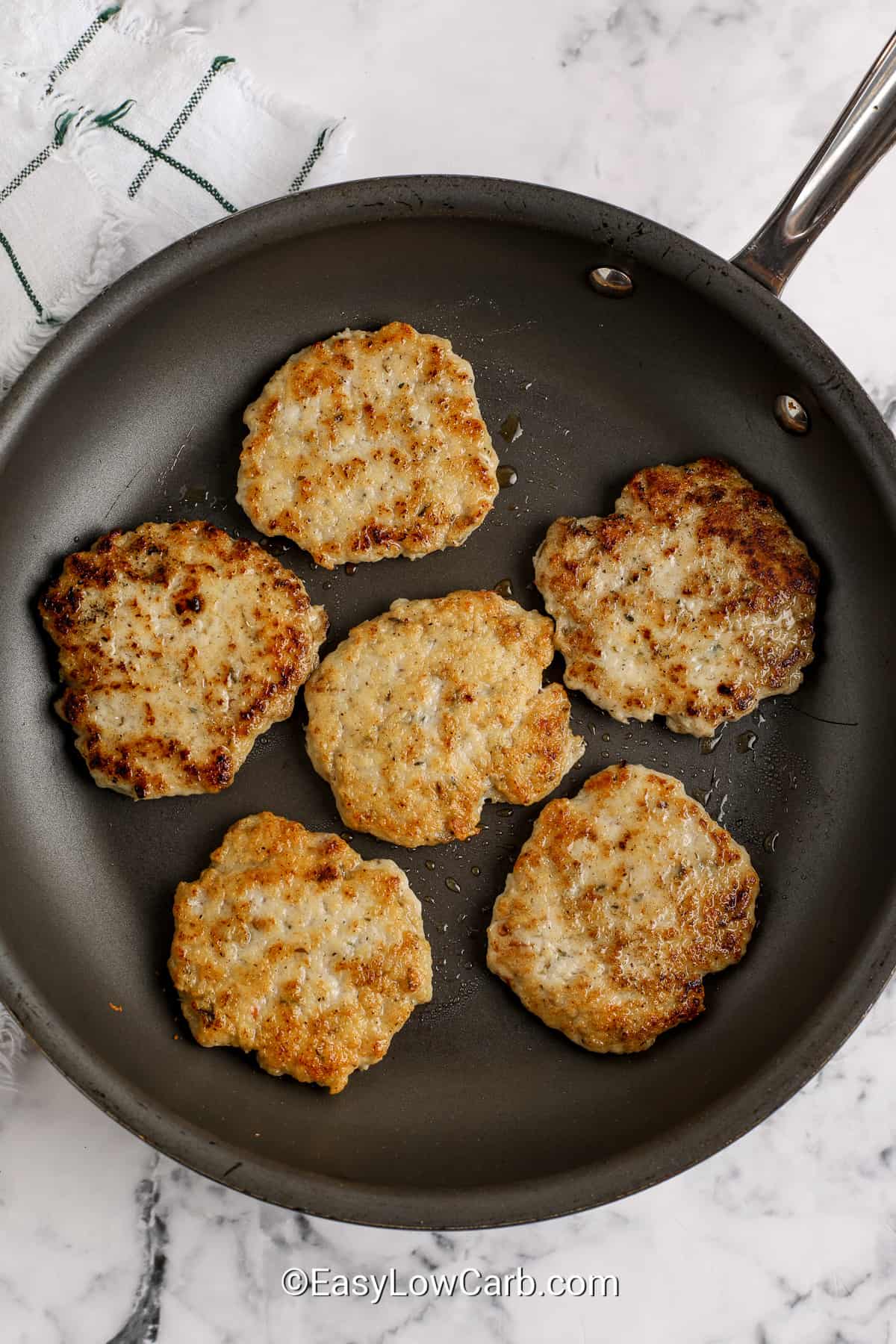 cooked turkey breakfast sausage patties on a frying pan