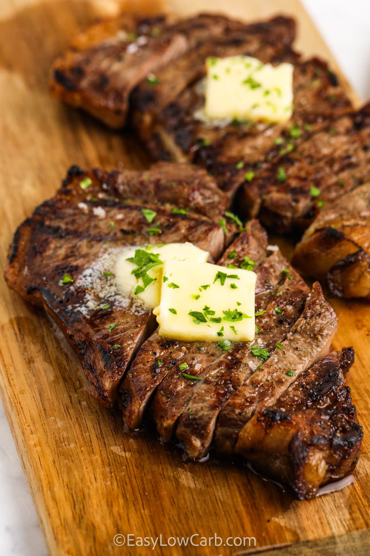 Grilled Striploin on a wooden board with melted butter on top