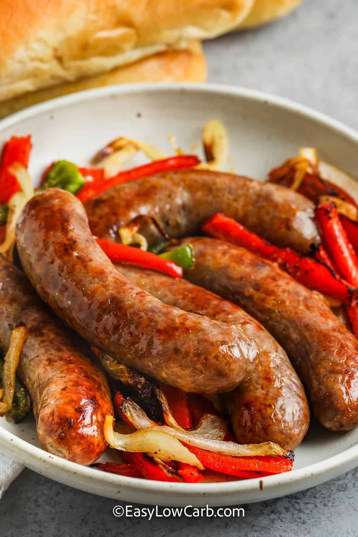 brats with peppers and onions on a plate