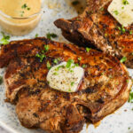Creamy Skillet Pork Chops on a plate with a side of sauce