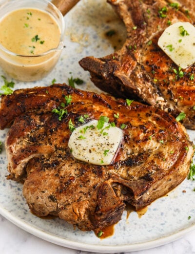 Creamy Skillet Pork Chops on a plate with a side of sauce