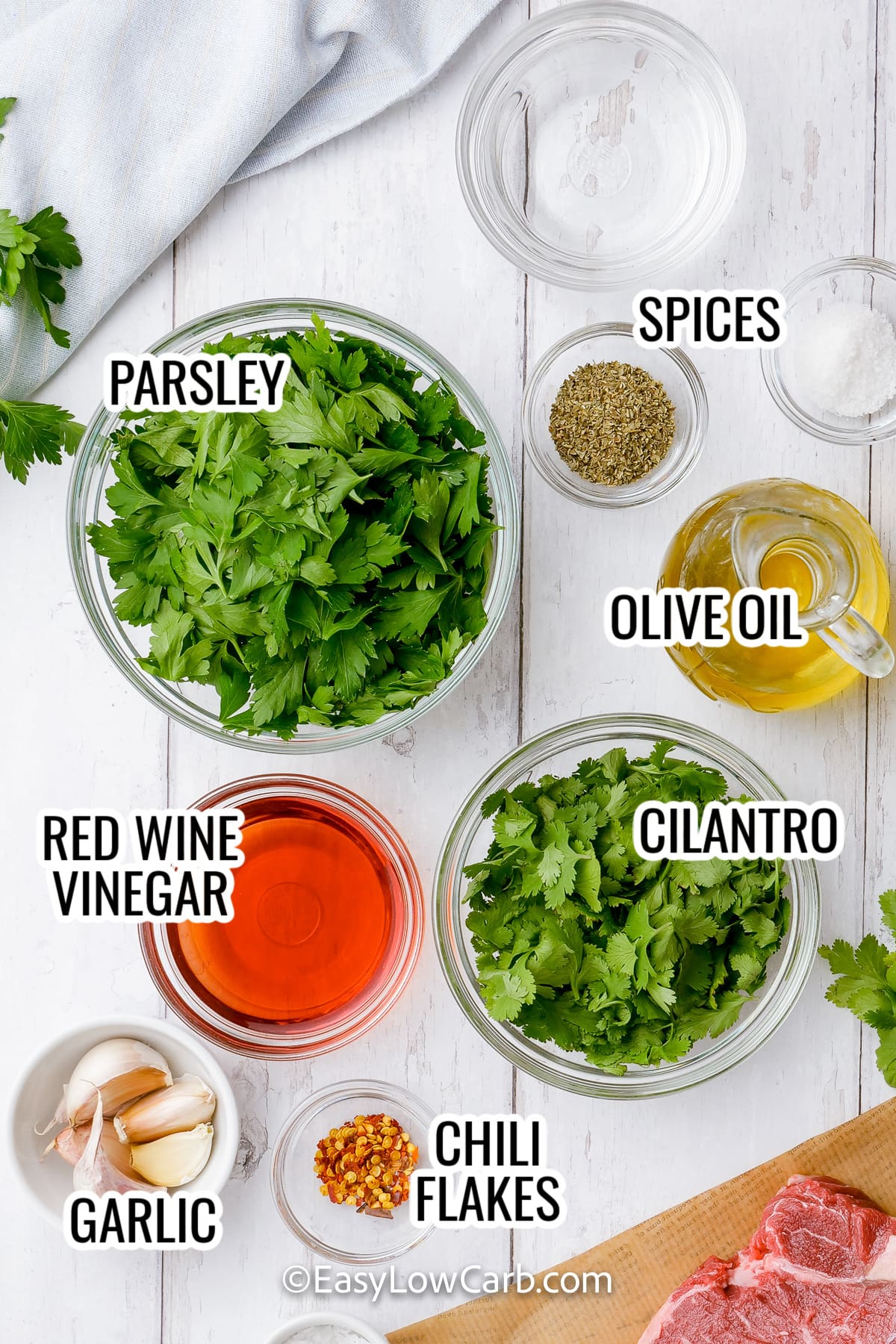 ingredients assembled to make easy chimichurri sauce including parsley, cilantro, olive oil, red wine vinegar, garlic and spices