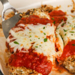 taking a piece of Low Carb Baked Chicken Parmesan out of the dish