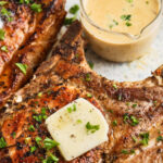Creamy Skillet Pork Chops on a plate with sauce and a title