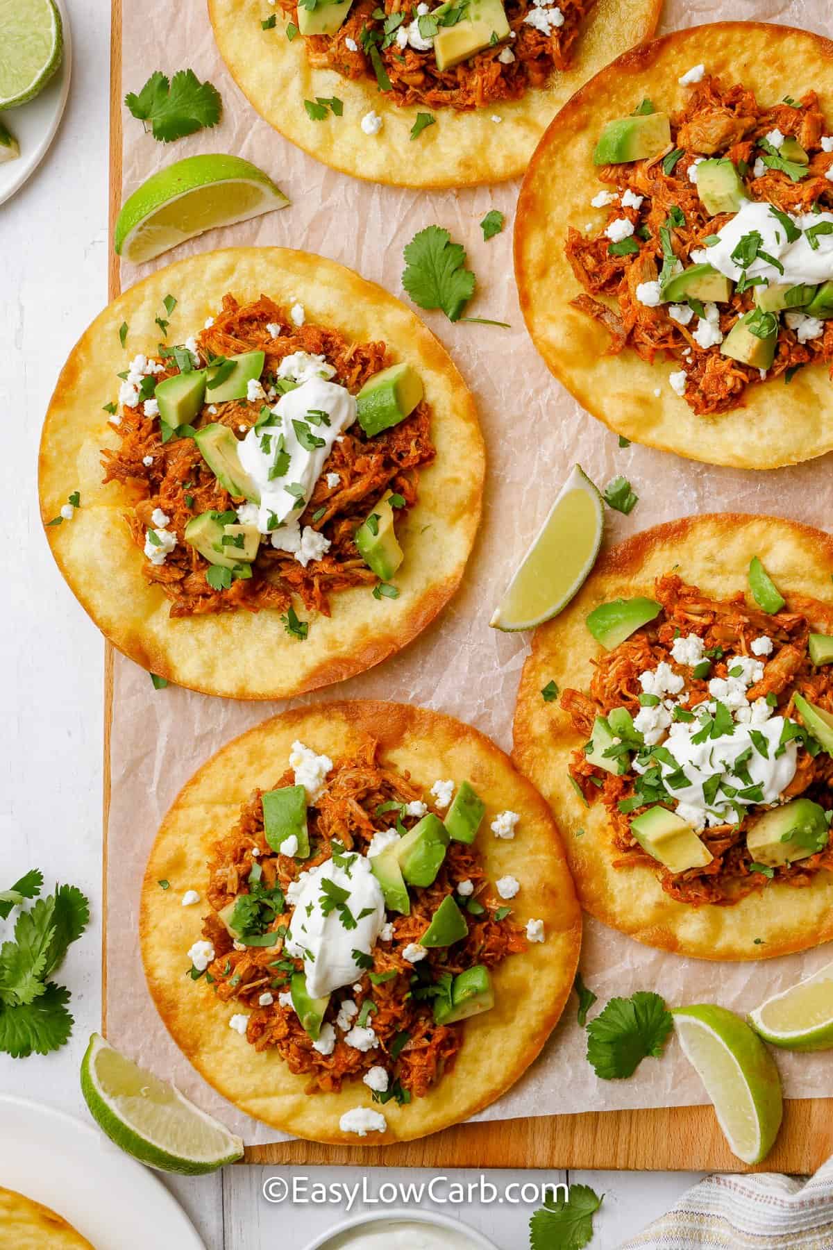 shredded pork tacos aligned on a cutting board