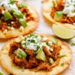 shredded pork tacos topped with sour cream, avocado, and cilantro