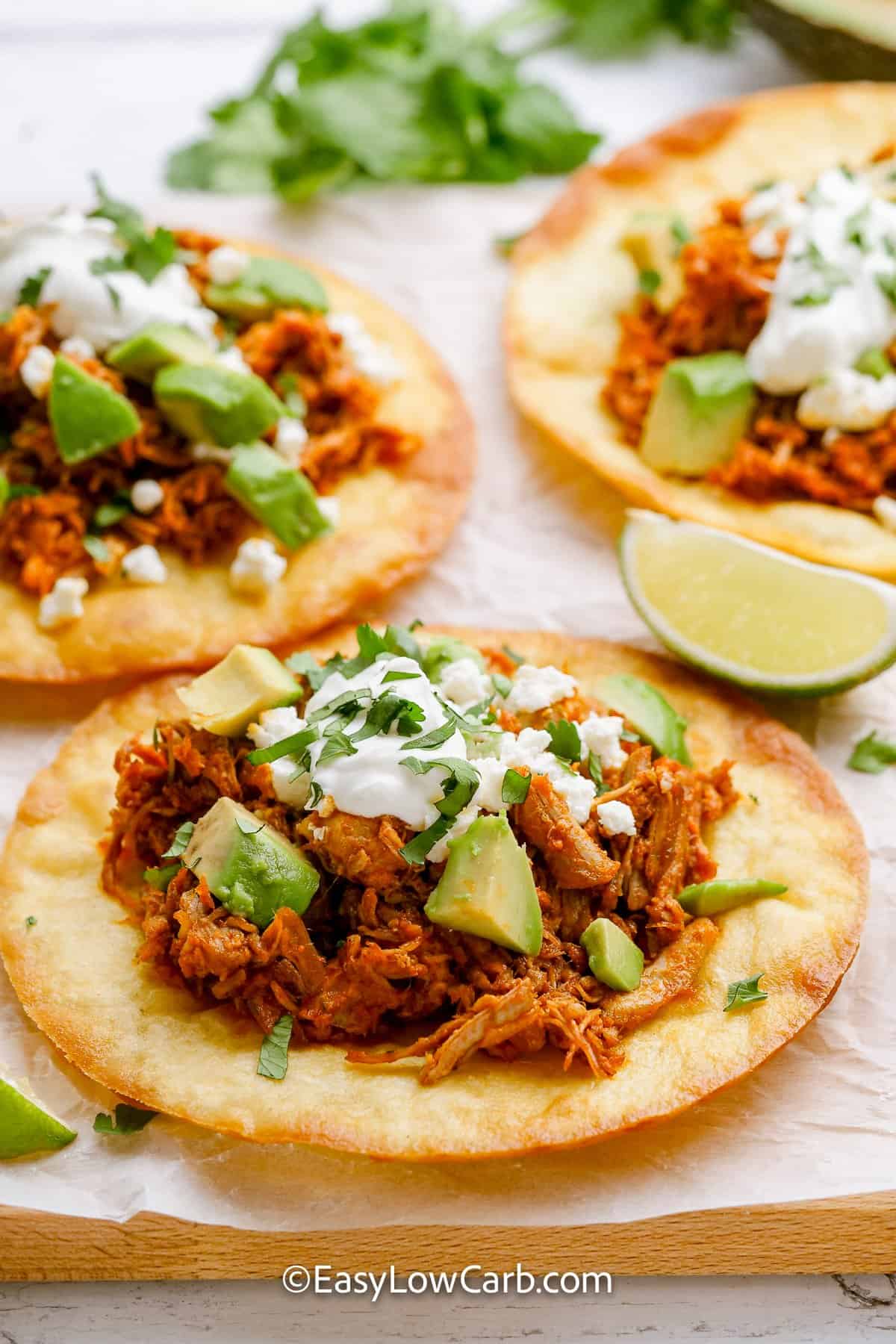 shredded pork tacos topped with sour cream, avocado, and cilantro