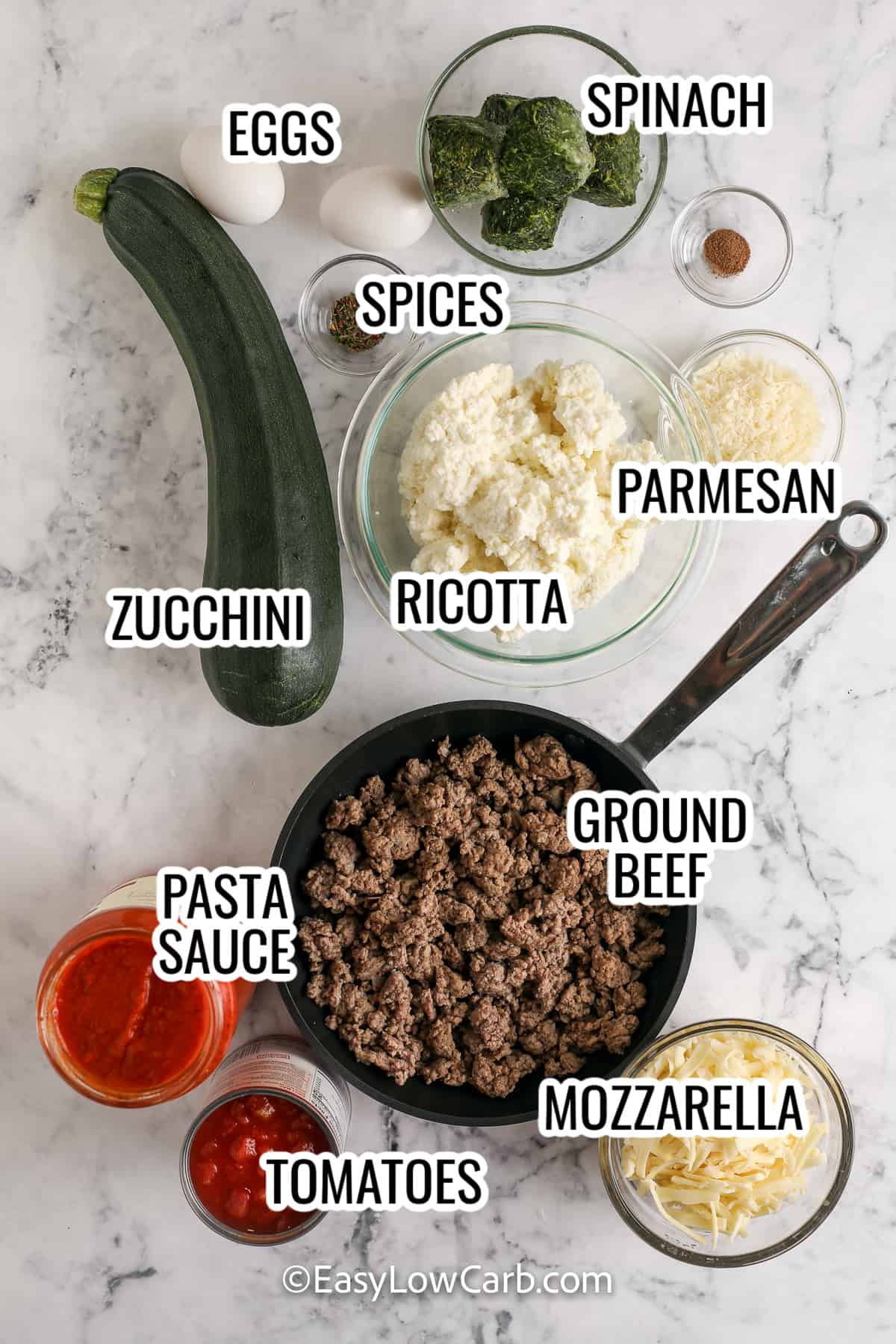 ingredients assembled to make low carb zucchini lasagna, including zucchini, ricotta, mozzarella, parmesan, spinach, and eggs,
