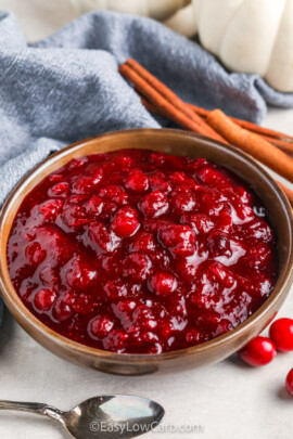 Keto Cranberry Sauce in a bowl with a spoon on the side