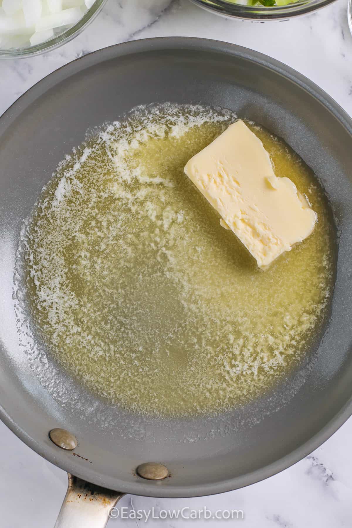 Keto stuffing brings the classic flavors of stuffing to a low carb table. Buttery toasted bread cubes, onions, celery, parsley, rosemary, and poultry seasoning are combined with chicken broth and baked to golden perfection. This simple, easy, and best recipe is perfect for holiday meals, Thanksgiving, or any family gathering, delivering a crowd-pleasing side that is comforting, flavorful, and perfect for sharing. #easylowcarb melting butter in pan to make Keto Stuffing