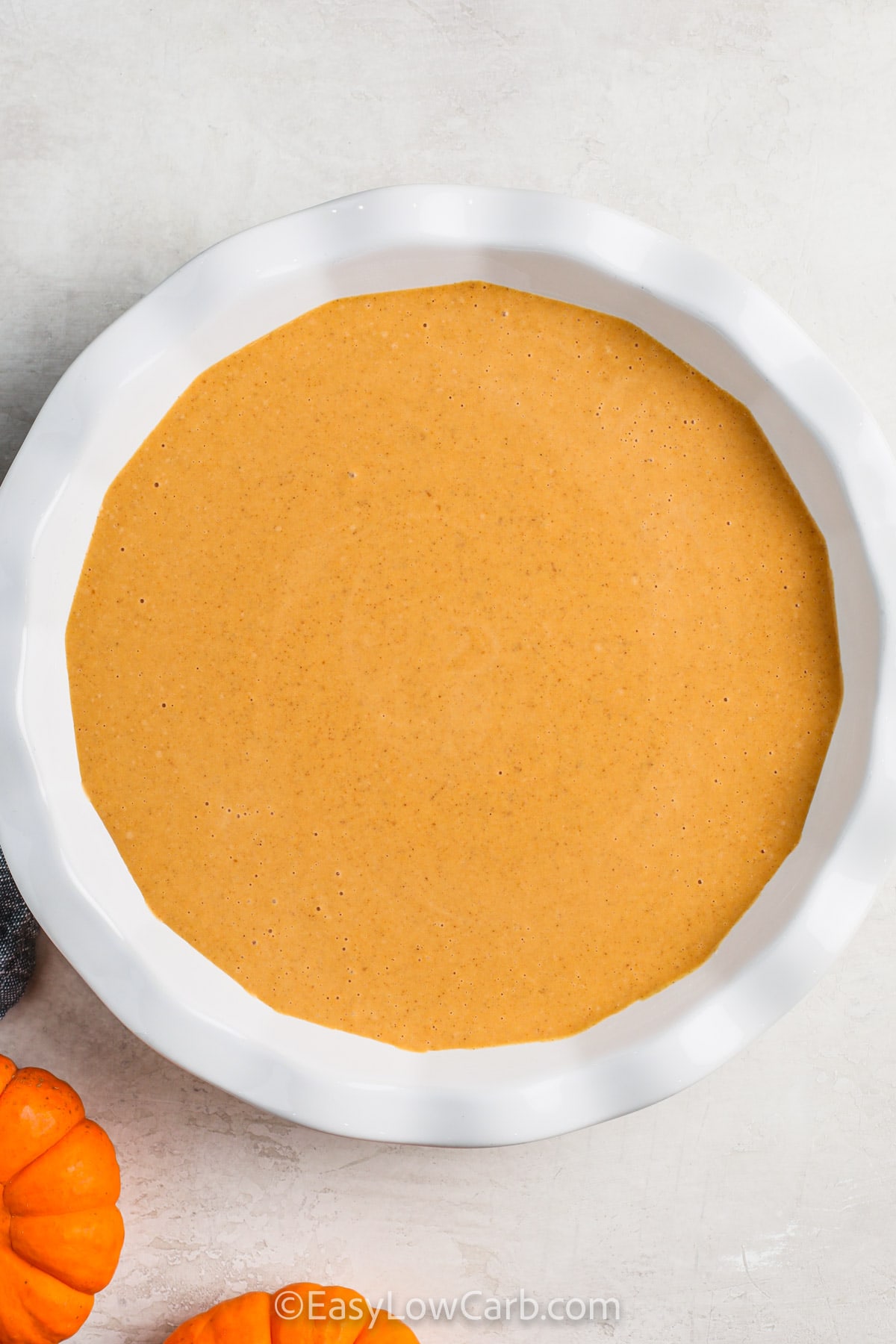 Keto pumpkin pie brings all the cozy flavors of fall into a low-carb treat that’s simple to make. Combining canned pumpkin, Swerve sweeteners, and aromatic spices like cinnamon and pumpkin pie spice, this pie is both festive and satisfying. It’s baked to perfection in under an hour and sets beautifully after chilling, making it an ideal make-ahead dessert. #easylowcarb Keto Pumpkin Pie Recipe in a dish before baking