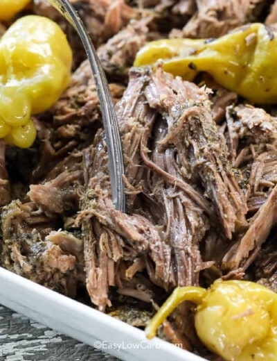 Slow Cooker Mississippi Pot Roast with pepperoncinis on top, pulled apart with a fork