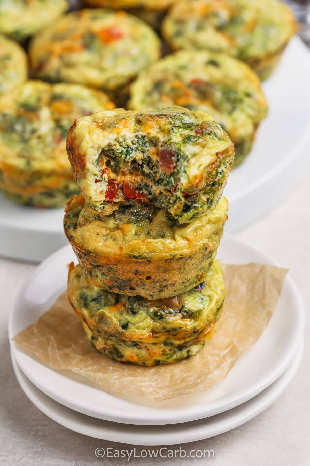Crustless mini quiche makes a comforting breakfast without crust. It's filled with bacon, veggies, and plenty of cheese. The simple mix goes right into a muffin pan and bakes into soft mini cups that are easy to serve. These little bites are perfect to make ahead for quick meals. Enjoy them warm from the oven or after chilling, since they keep their rich and tender texture each time #easylowcarb Mini Quiches with a bite taken out of one