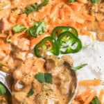 taking a spoonful of Keto White Chicken Chili out of the pot with writing