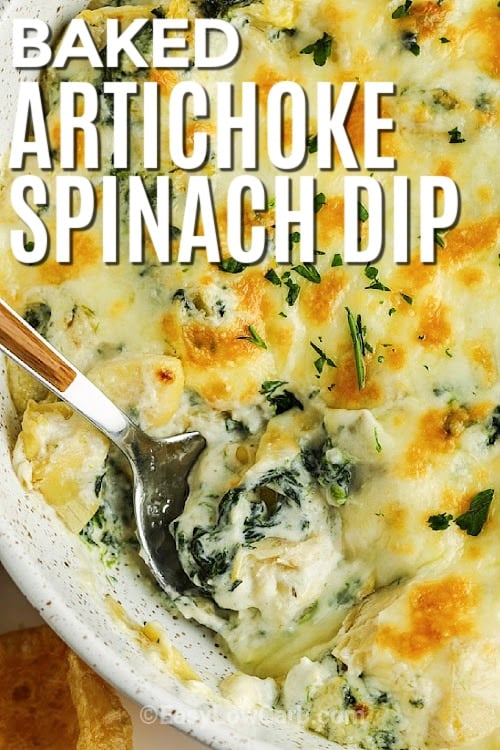 baked artichoke spinach dip in a dish with a spoon in the dip, with a title