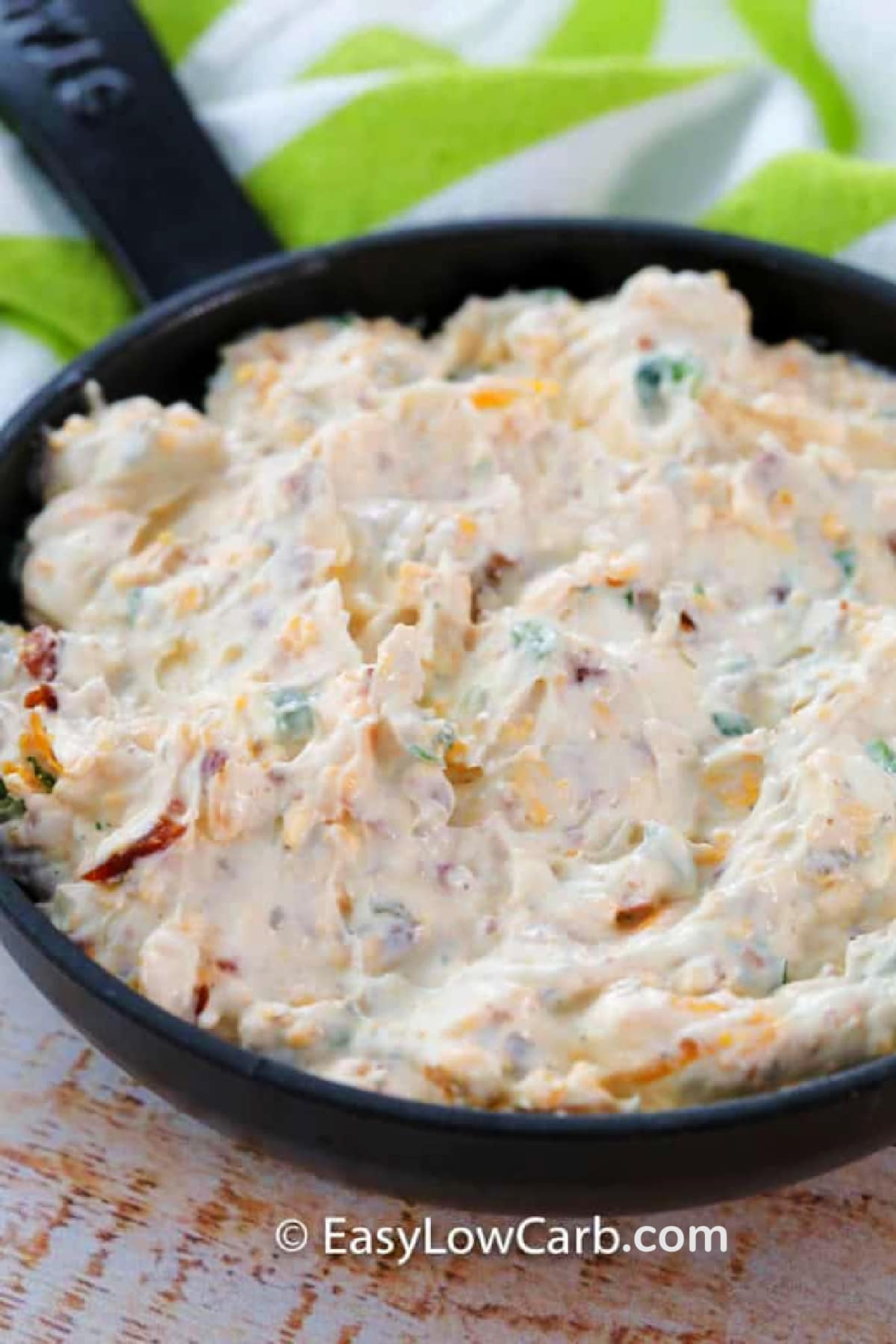 uncooked warm bacon dip in a cast iron skillet