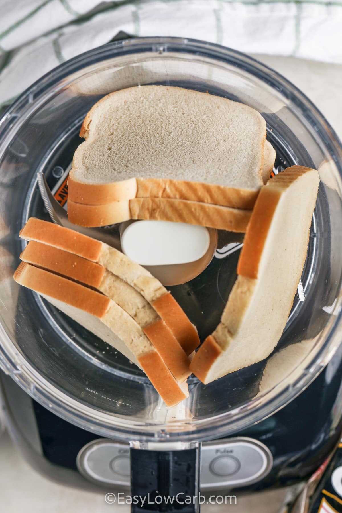 close up of bread in a food processor to make Keto Breadcrumbs