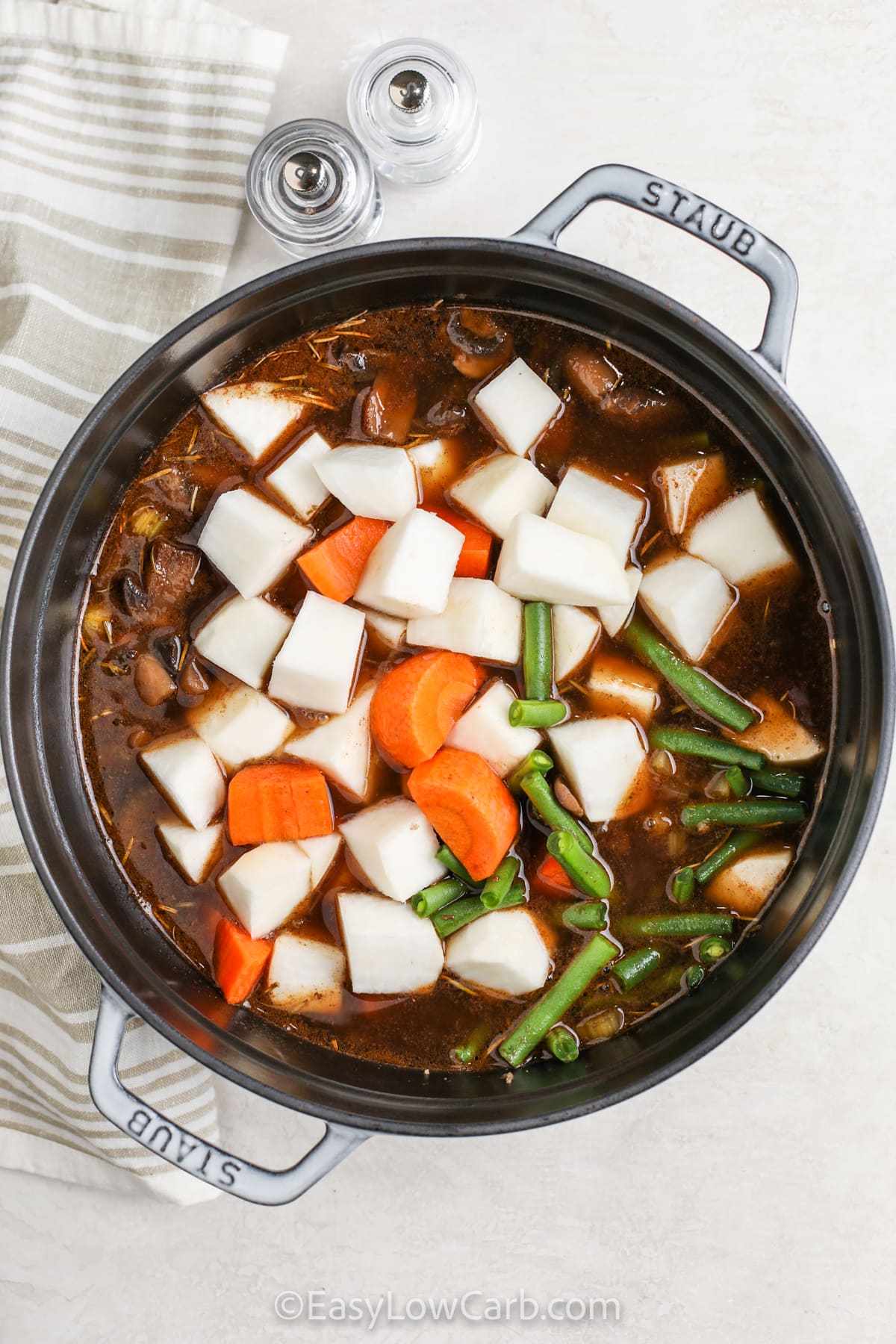 adding remaining vegetables to pot to make Low Carb Beef Stew