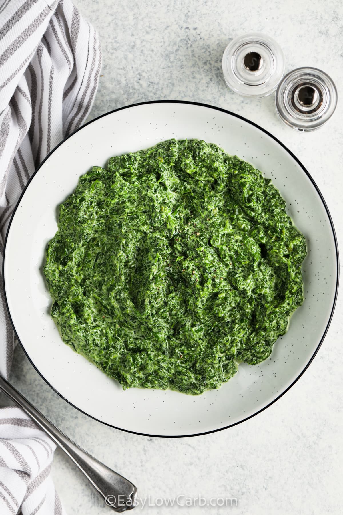 This recipe for Creamed Spinach combines spinach with a rich cream reduction seasoned with garlic powder, onion powder, and nutmeg. The result is a smooth, velvety side dish that fits perfectly into low carb or keto meals. It cooks quickly in one skillet and pairs well with your favorite proteins. It’s a steakhouse favorite for good reason. Its warmth, texture, and ease make it a great choice for any night of the week. #easylowcarb plated Easy Creamed Spinach