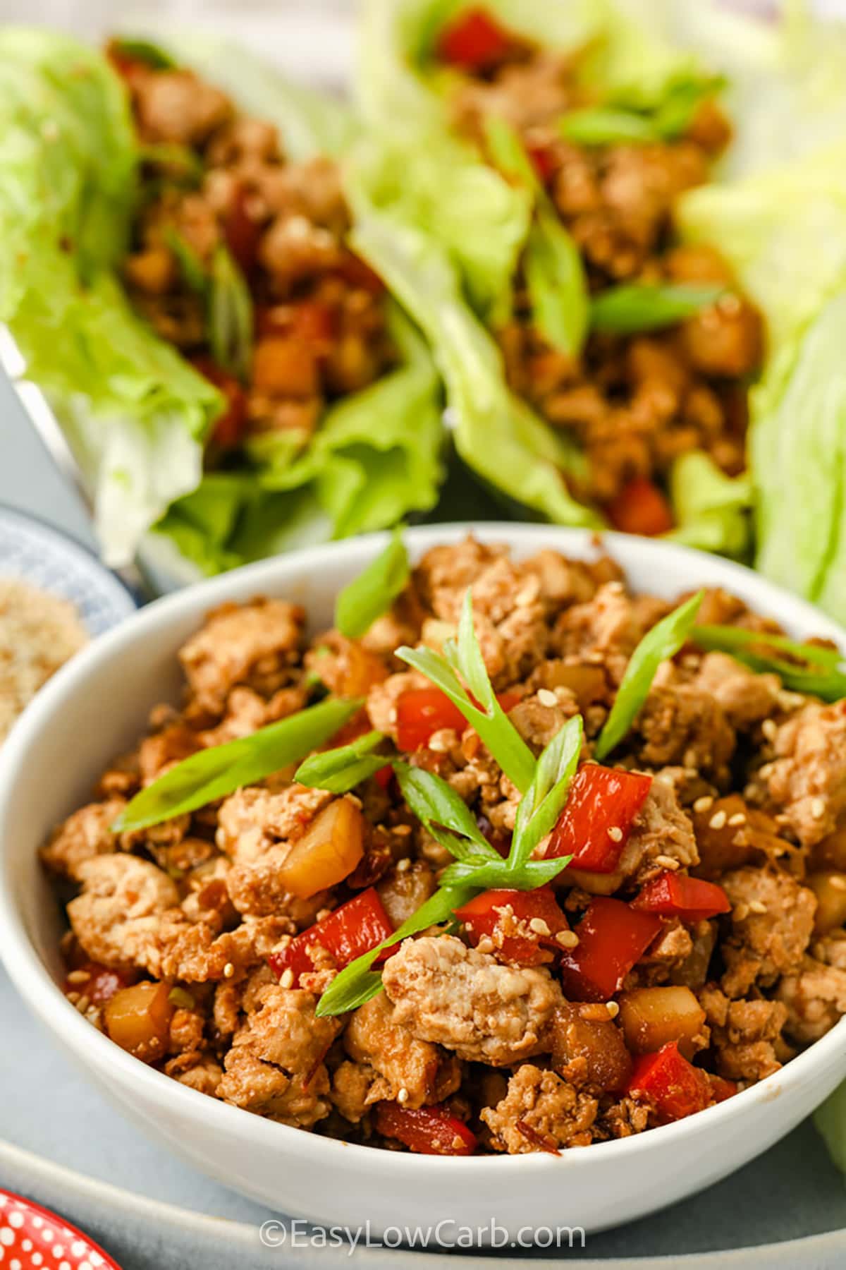 Chicken Lettuce Wrap filling in a bowl with wraps in the back