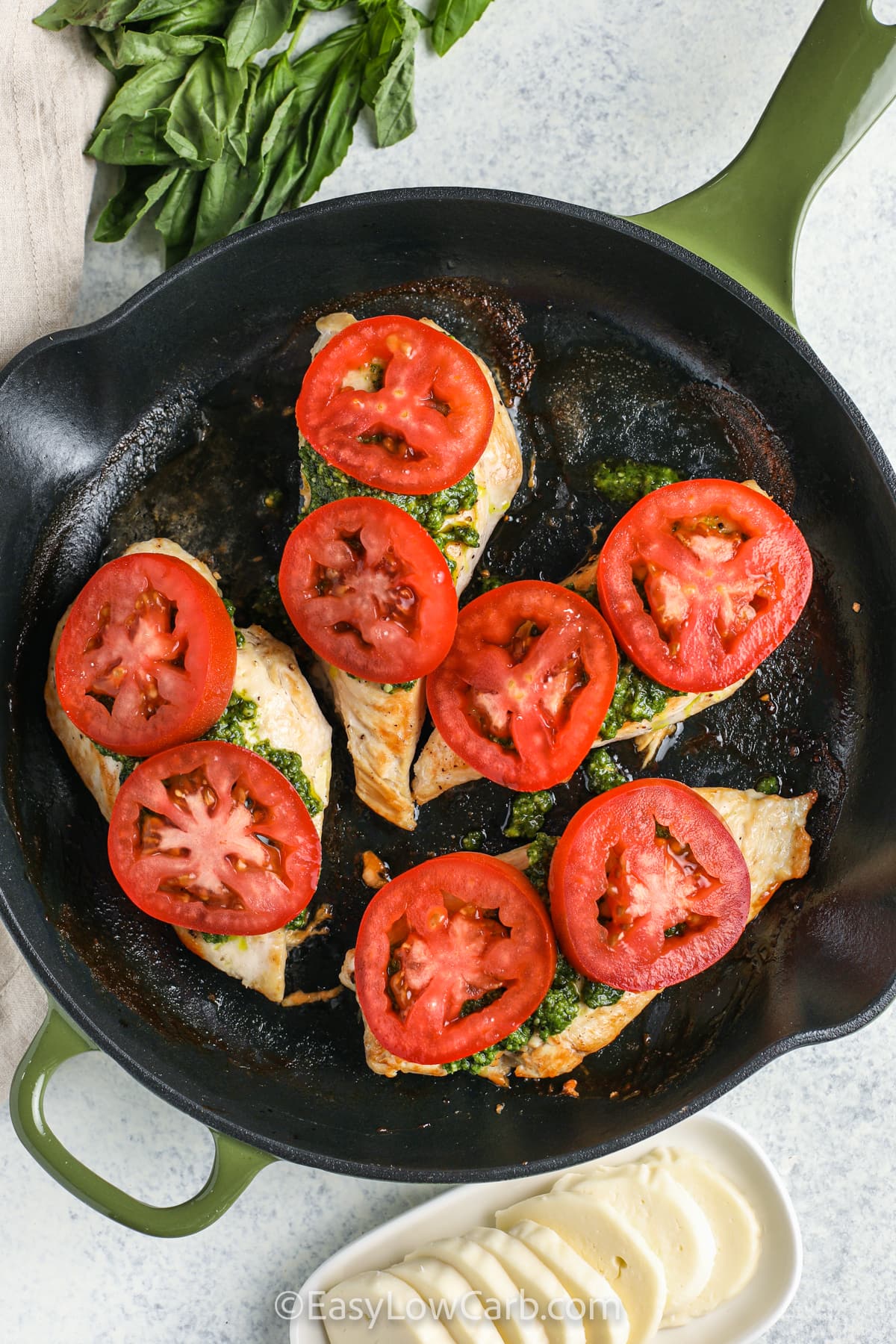 adding tomatoes to chicken to make Caprese Chicken Recipe