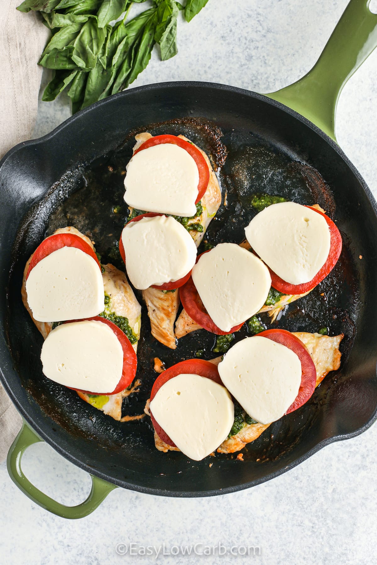 adding mozzarella to chicken to make Caprese Chicken Recipe