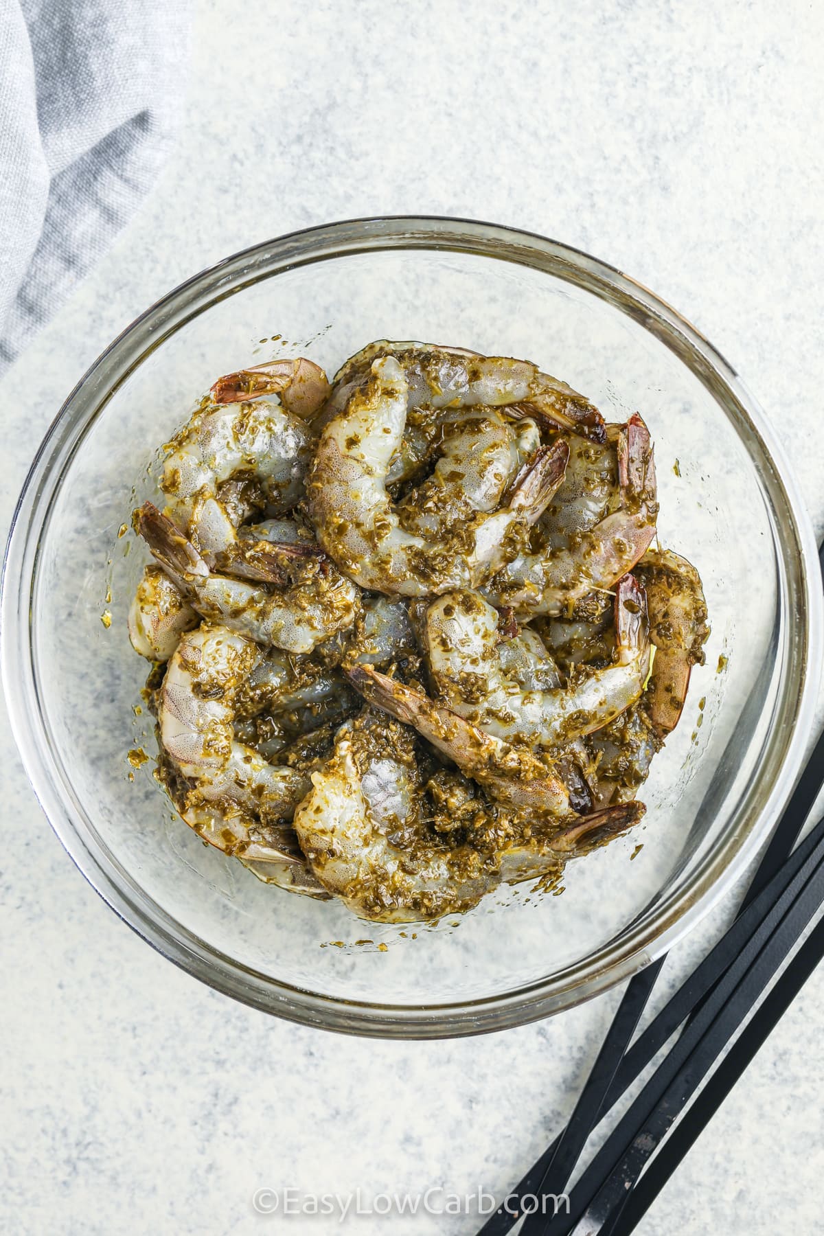 adding pesto and lemon juice to shrimp to make Grilled Shrimp Kabob Recipe.