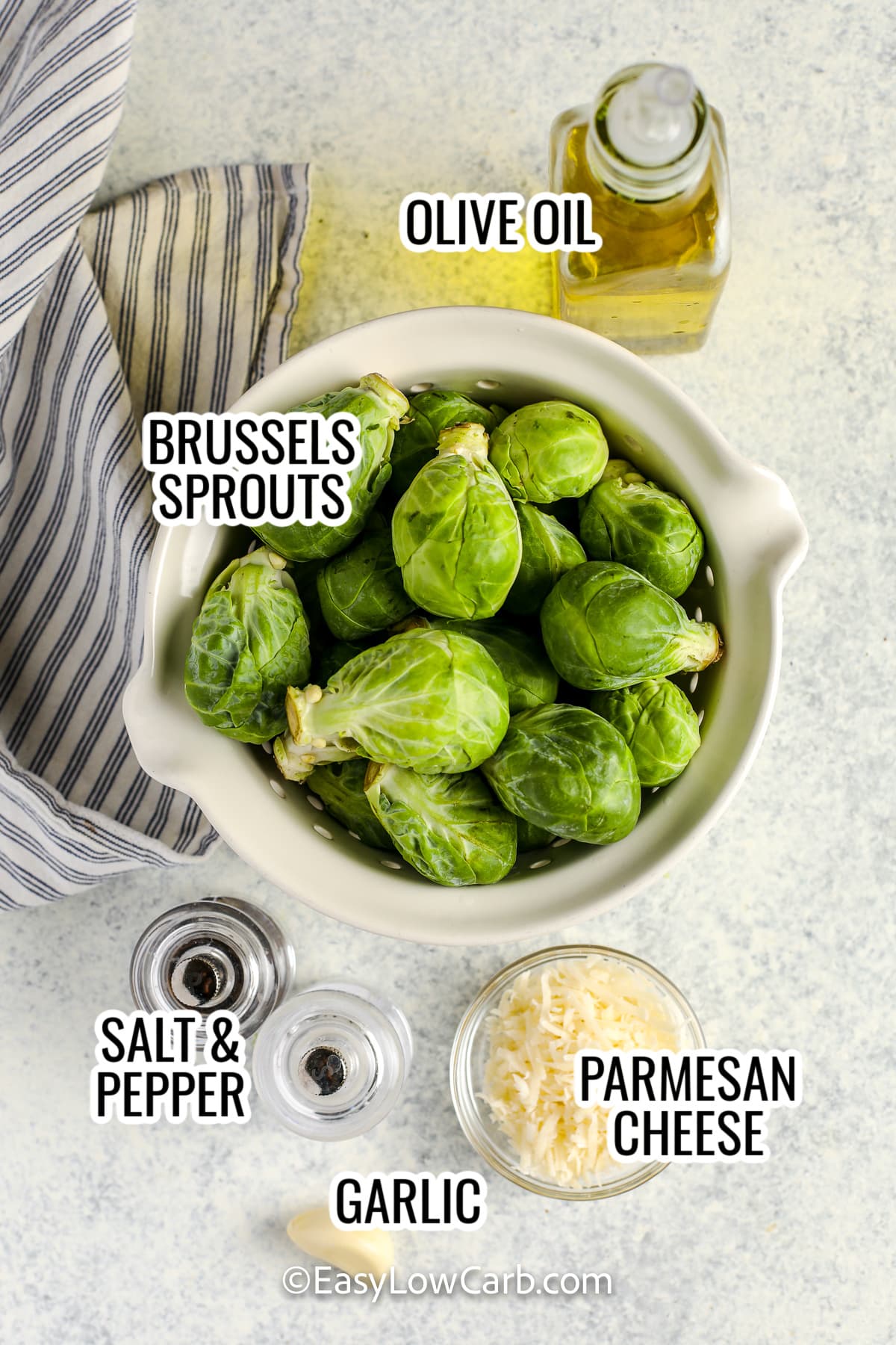 ingredients assembled to make grilled brussels sprouts, including brussels sprouts, olive oil, salt and pepper, garlic, and parmesan cheese