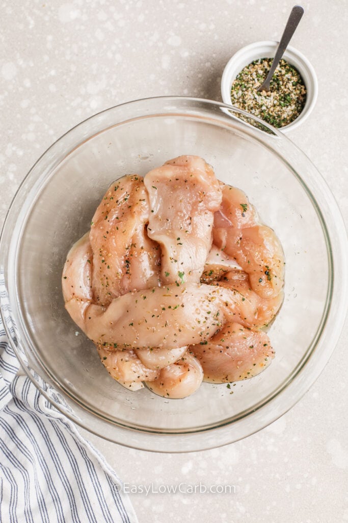 Seasoned chicken in a glass bowl to make bacon wrapped chicken