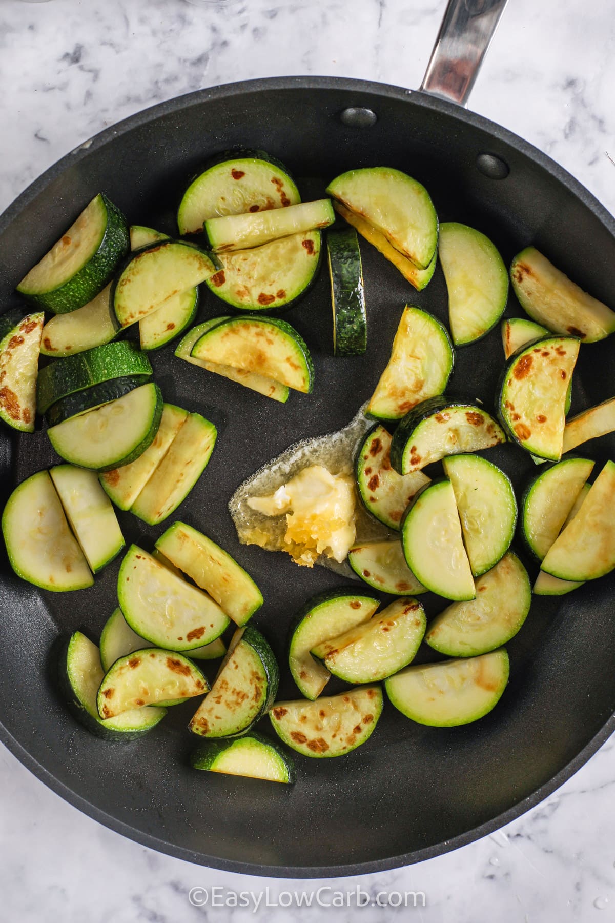 adding butter and garlic to zucchini to make Sauteed Zucchini