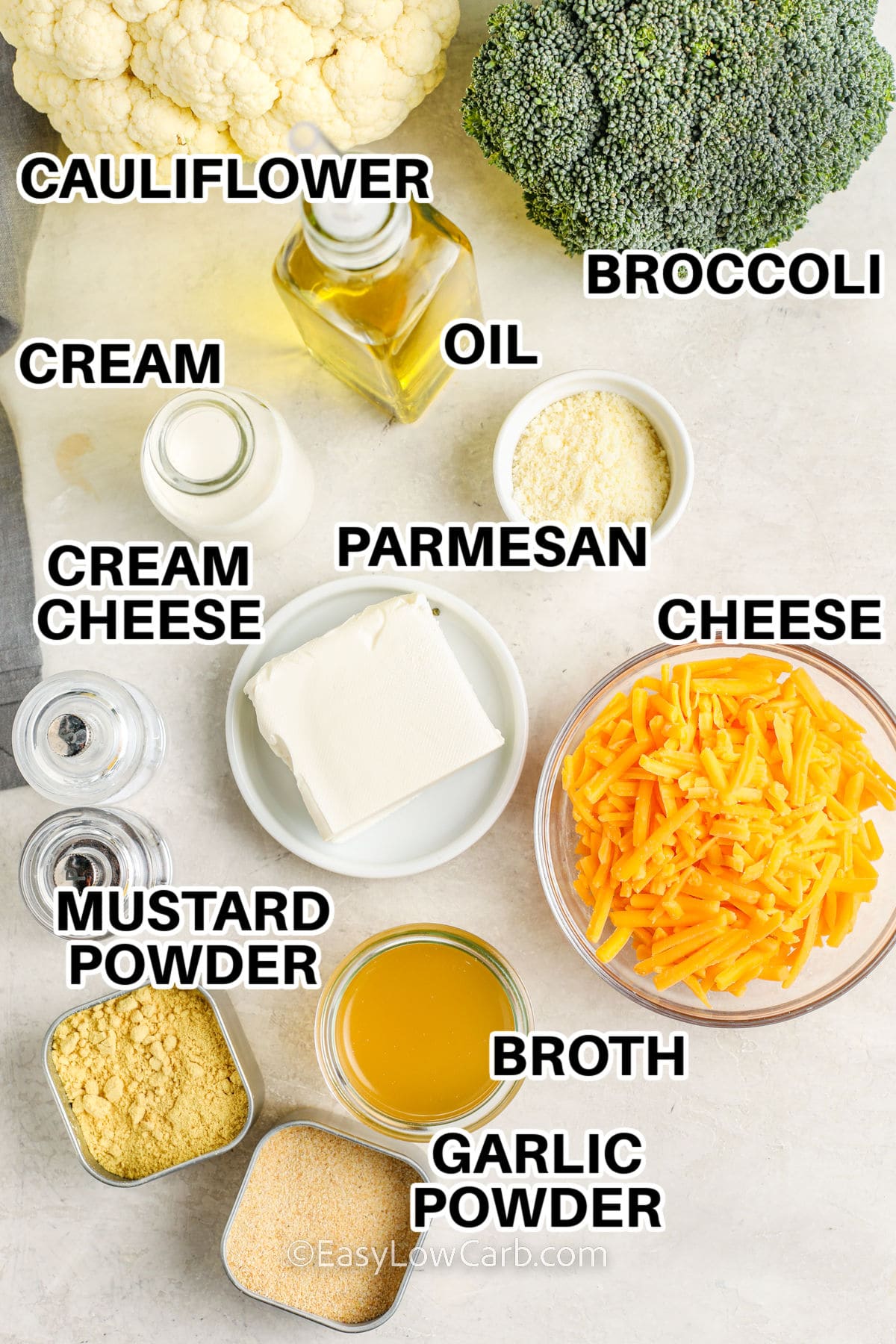 ingredients to make broccoli cauliflower casserole labeled: cauliflower, broccoli, oil, cream, cream cheese, parmesan, cheese, mustard powder, broth, and garlic powder.