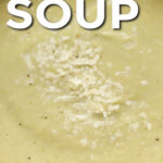 A pot of cauliflower leek soup topped with parmesan cheese with text