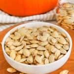 baked pumpkin seeds in a white bowl