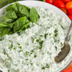 spinach dip in a bowl with a spoon