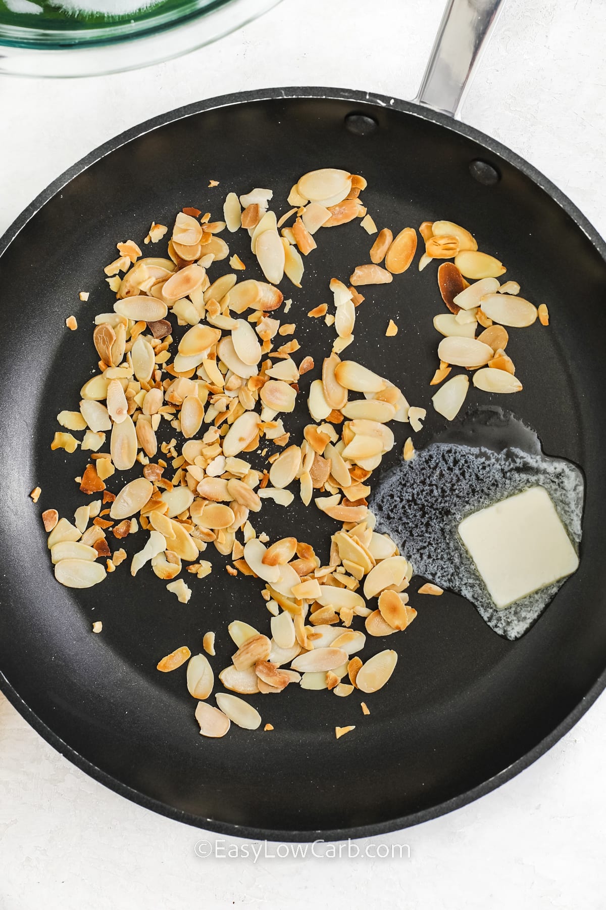 toasted sliced almonds in a frying pan with butter for Green Beans Almondine