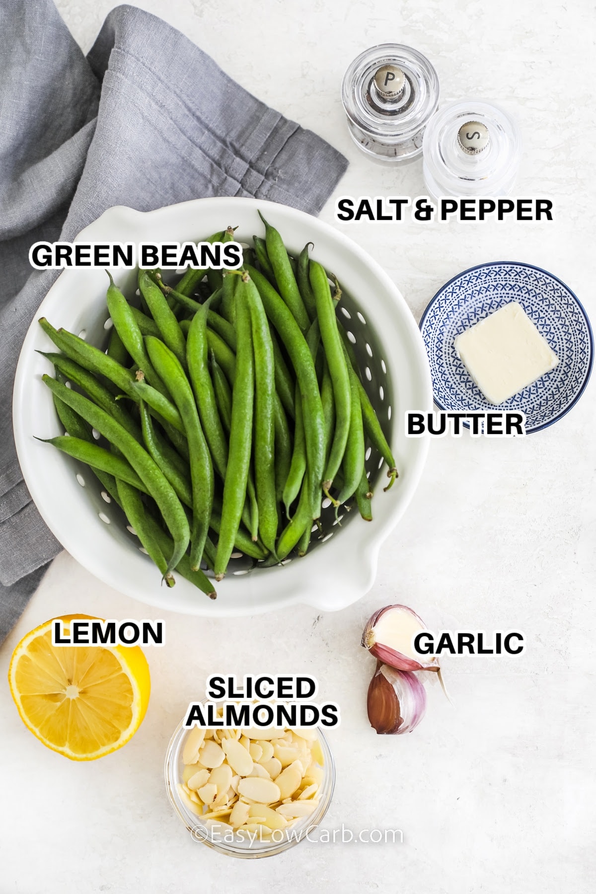 Ingredients to make green beans almondine labeled: green beans, butter, lemon, sliced almonds, garlic, salt, and pepper