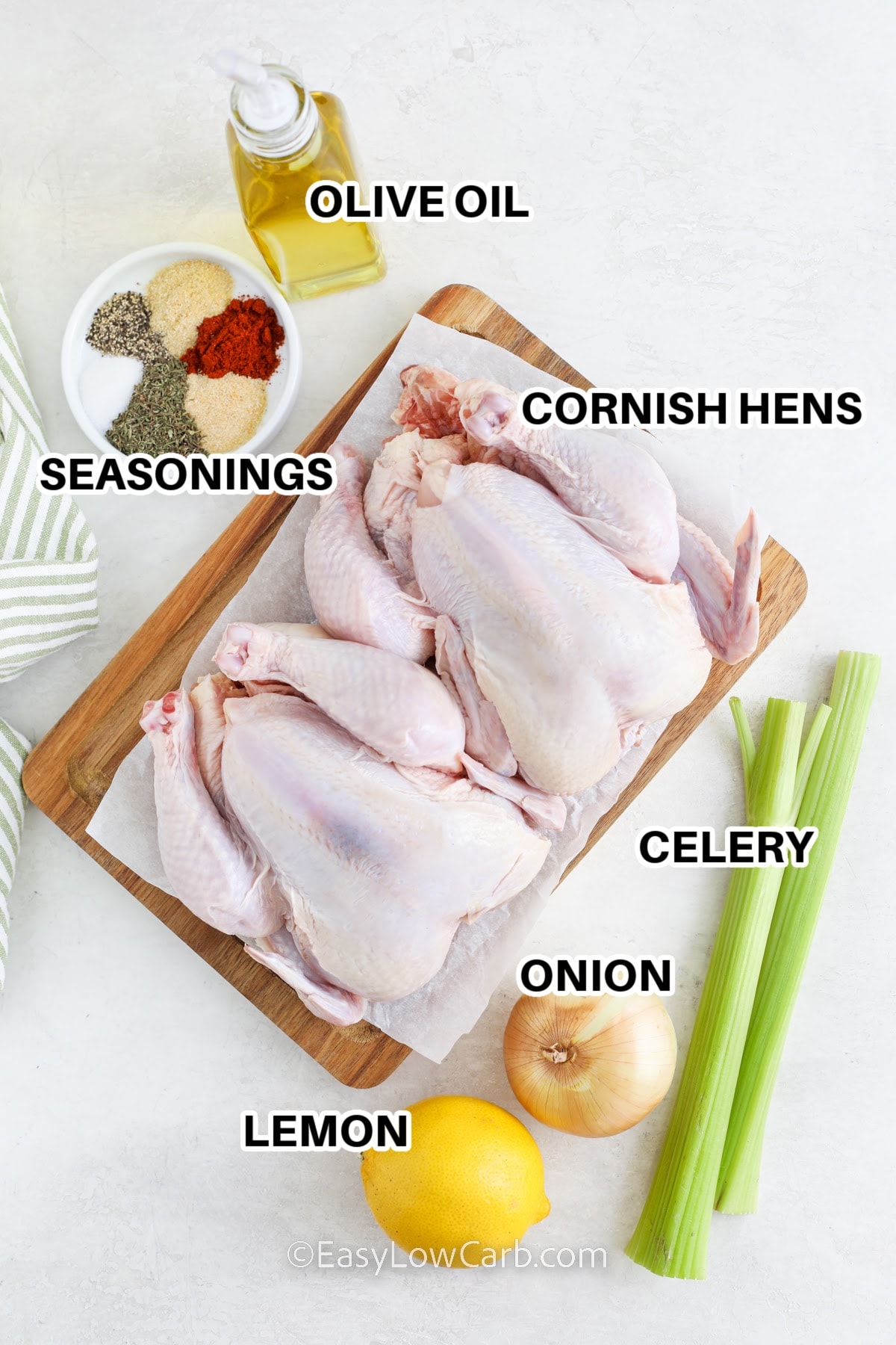 Ingredients to make roasted Cornish hens labeled: olive oil, seasonings, lemon, onion, celery, and Cornish hens.