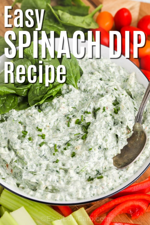 spinach dip in a bowl with a spoon and writing