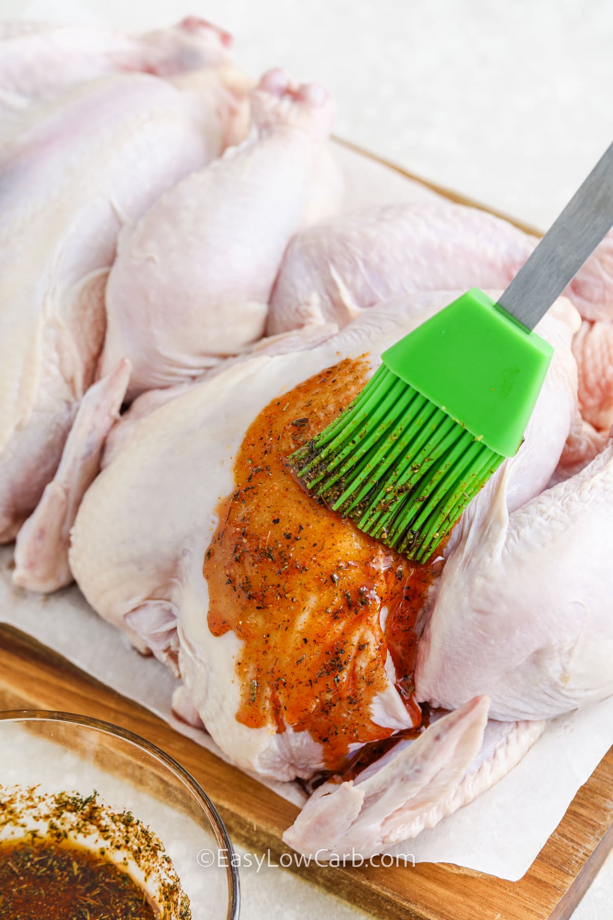 Cornish Hen being brushed with a seasoning mixture