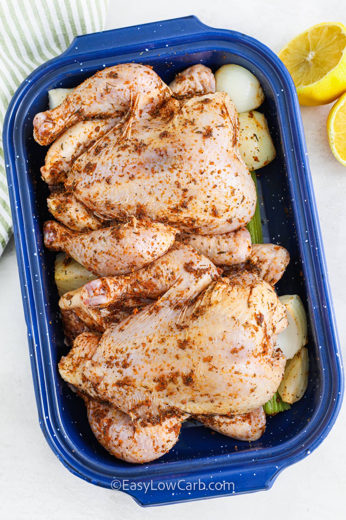 Seasoned Cornish Hens in a bed of celery and onions in a roasting pan